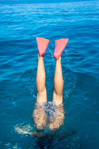 istock Snorkelling flippers descend into  blue waters 1426708483
