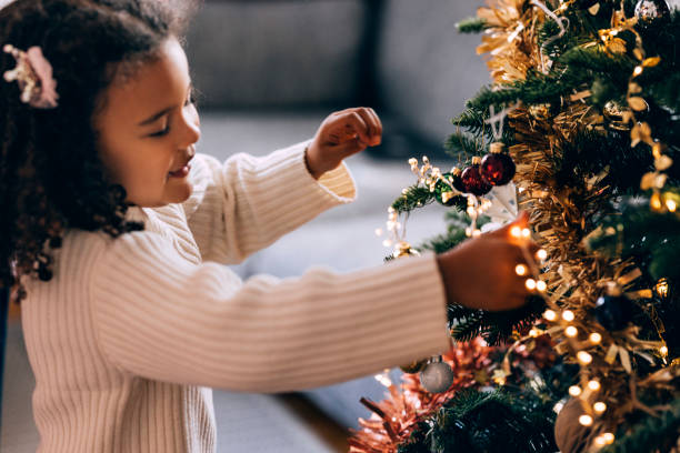istock Girl Putting On Christmas Lights On A Christmas Tree 1426708958