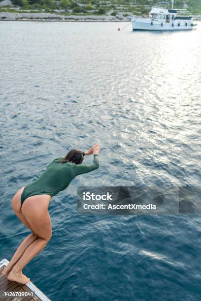 Young Woman Dives Into Sea From Boat Stock Photo - Download Image Now - Water, Rear View, Sea