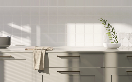 Moderna, contemporánea y lujosa encimera de cocina de madera incorporada verde caqui con parte superior laminada y pared cuadrada de azulejos blancos a la luz del sol desde la ventana photo