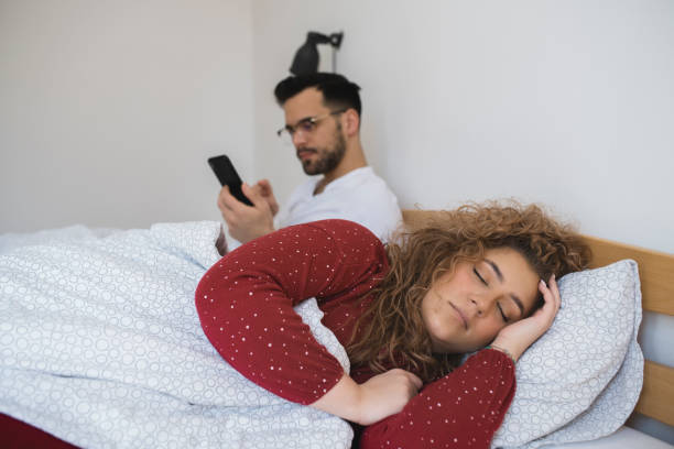 istock Woman sleeping while her husband surfing the net in the morning 1426728395