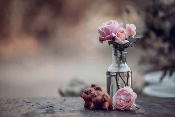 Dried floral arrangement in pink and brown hues.  The flowers lie at top of a wooden table with light blue background.  Copyspace.