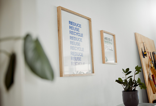 Reduce, reuse and recycle poster hanging in an office as a mantra to conserve, protect and save planet earth. A framed picture on a wall in a creative, trendy and modern design office or workshop