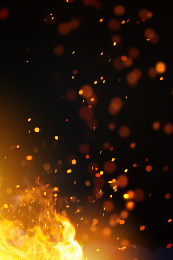 Close-up of sparkler in shape of 'NUMBER 7' emitting sparks while burning against black background.