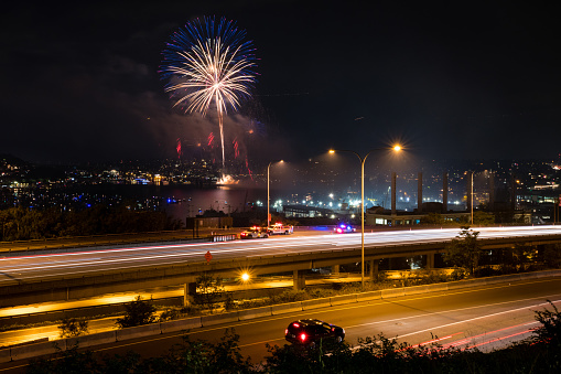 Seattle, USA - July 4th, 2019: Fireworks over lake union as an SUV dangerously stops on northbound Interstate 5 just after 10:20pm as the fireworks start.