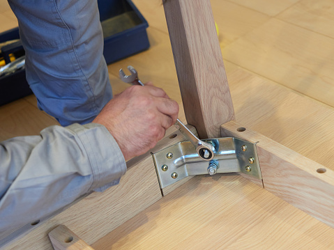 Asian man assembling furniture