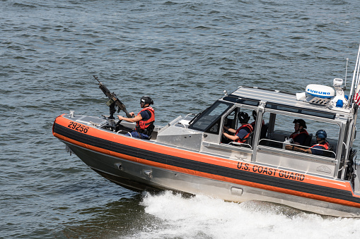 New York, USA - Jul 24, 2019: The Coast Guard patrolling the New York harbor off Lower Manhattan and escorting the Staten Island Ferry late in the day.