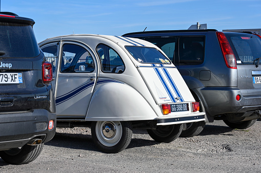 Saint-Cast-le-Guildo, France, September 17, 2022 - A vintage classic Citroen 2CV (Dodoche), 1983 special model France 3 parked next to a row of modern SUV vehicles