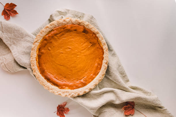 Traditional fall season pumpkin pie on the white table, top view. Autumn food