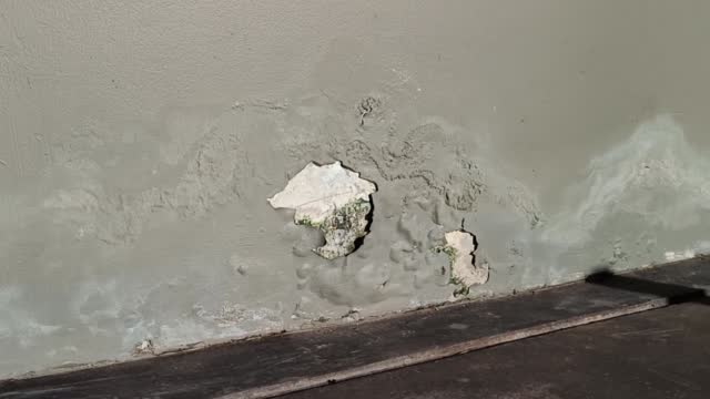 walls of the old building are cracked, poorly repaired, with peeling paint.