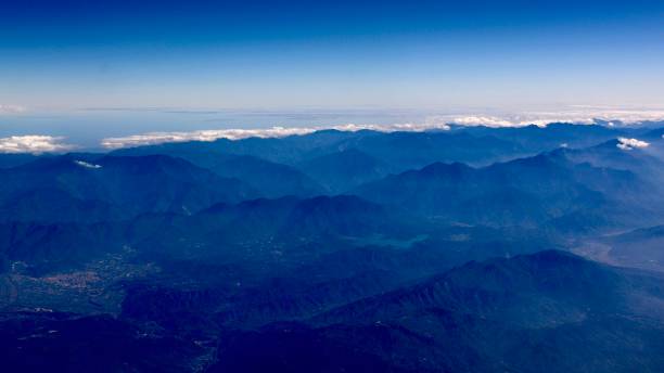 Clouds, mountains, the river, the lake, and the villages View from the window of the aircraft on my way from Osaka to Taiwan. I never climb high mountains, so I took the chance to take photos of them. stratosphere airplane cloudscape mountain stock pictures, royalty-free photos & images
