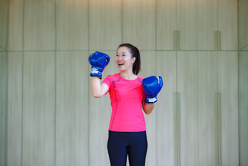Asian woman in gym clothes boxing exercises
