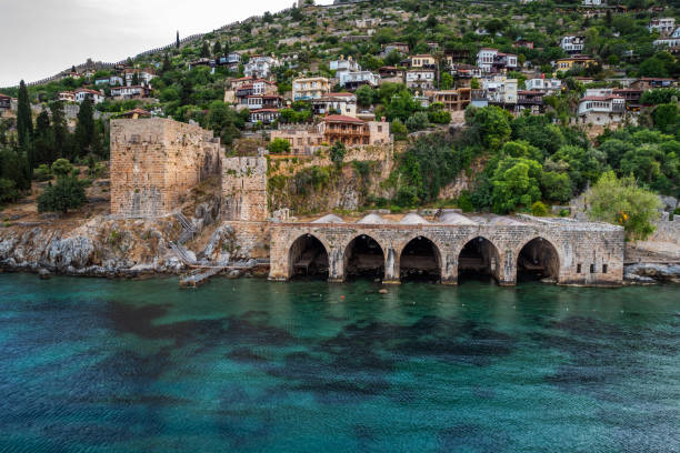 Aerial view of ancient shipyard near of Kizil Kule tower in Alanya peninsula, Antalya district, Turkey, Asia. Famous tourist destination with high mountains. Part of ancient old Castle.
