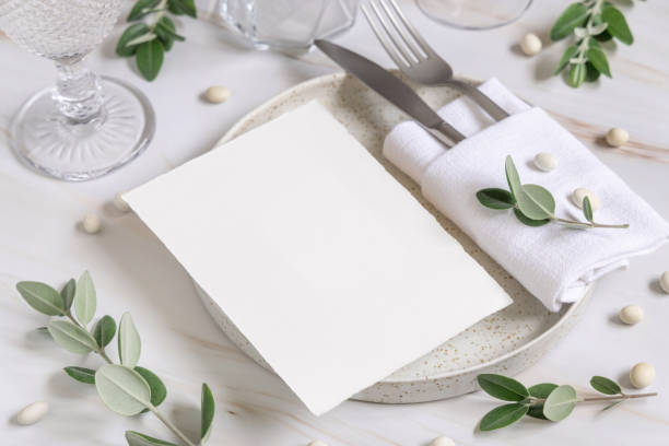 istock Elegant Table setting with a card decorated with eucalyptus branches close up, Wedding mockup 1426805528