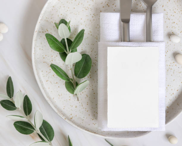 istock Elegant Table setting with a card decorated with eucalyptus branches top view, Wedding mockup 1426805530