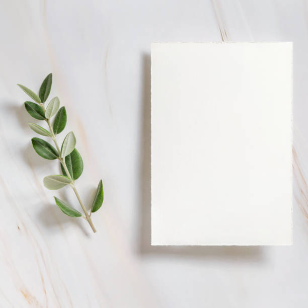 istock Vertical card on a marble table decorated with eucalyptus branches top view, Wedding mockup 1426805540