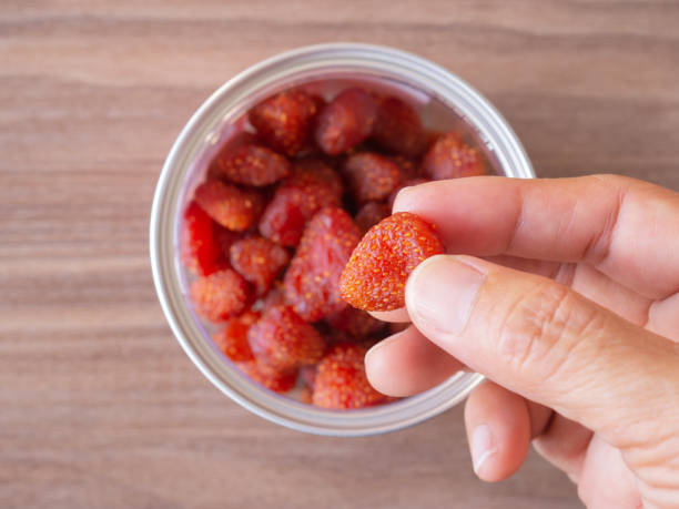 cueilli à la main des fraises séchées dans une boîte de conserve sur la table. vue de dessus, espace de copie. - dry strawberry dried food fruit photos et images de collection