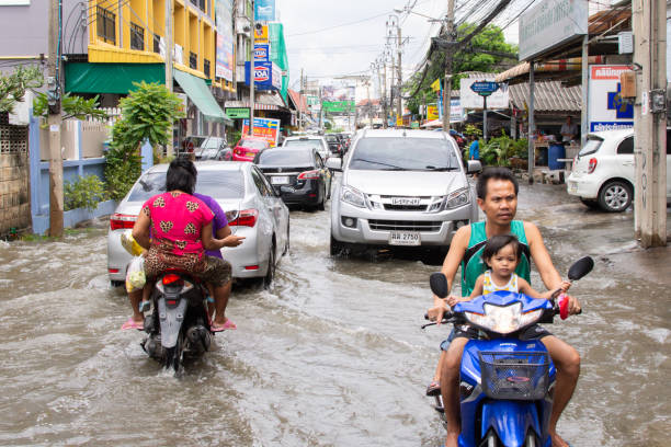 Water flood in city problem with drainage system Bangkok, Thailand - September 25, 2016 : Water flood in Bangkok city problem with the manhole overflow in drainage system it full from garbage when rain storm. bangkok street stock pictures, royalty-free photos & images