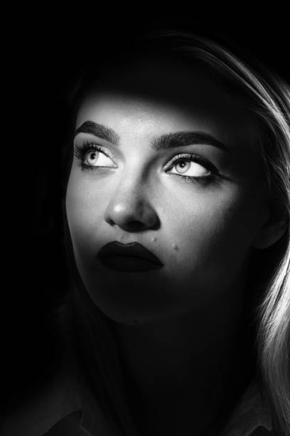 istock Beautiful woman portrait partly face covered with shadow 1426813224