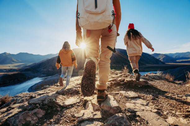 istock Three tourists hikers walks in sunset mountains 1426823189