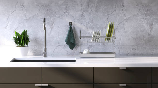 istock Modern and minimal built-in gray kitchen counter with white laminate top, sink and white marble tile wall in sunlight from window 1426824552