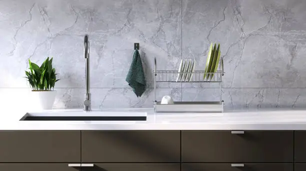 Photo of Modern and minimal built-in gray kitchen counter with white laminate top, sink and white marble tile wall in sunlight from window