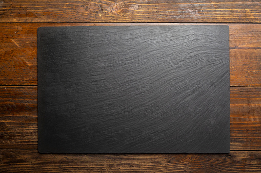 Empty cutting slate board on planks food background concept. Top view.Space for text.