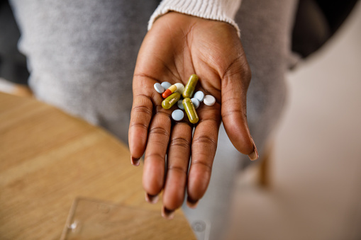 Close-up shot of various pills on woman's palm.