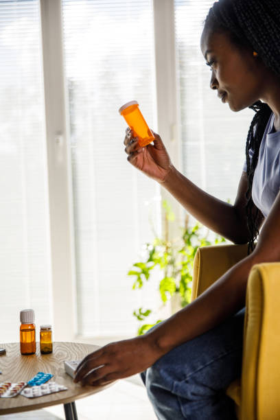 istock Young Black woman reading a label on a pill box 1426832194