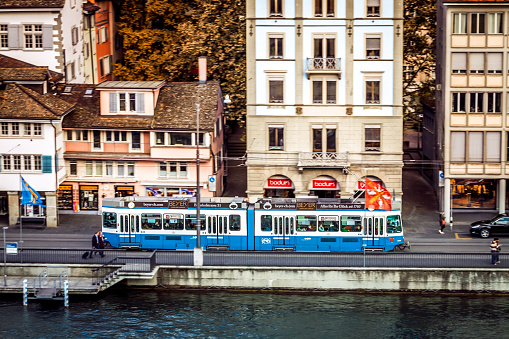 Zurich, Switzerland - October 5, 2016: Tram is the most convenient transport in Zurich city, stops at Helhaus bridge in the city centre.  Sometimes combined with bicycle. Panning photo.