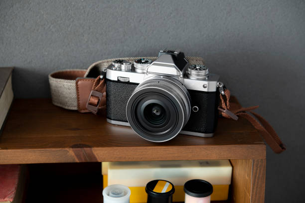 Retro Film Camera Old fashioned 35mm camera with slide film on bookshelf photographic film camera stock pictures, royalty-free photos & images