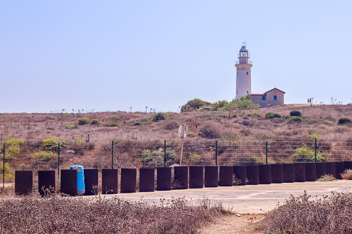 A giant white lighthouse stands proud at the coast of Paphos, Cyprus. The lighthouse can be seen and admired for miles around.