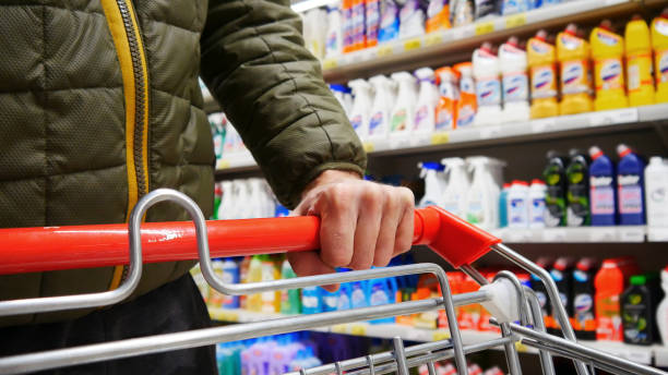 Close-up of a male buyer's hand pushing a shopping cart in a household chemicals department stock photo