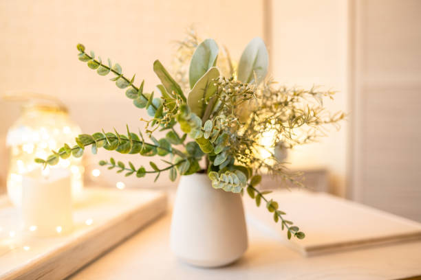 istock Christmas decoration with tray, candle, garland lights, christmas tree and eucalyptus branches in a vase on the table 1426849680