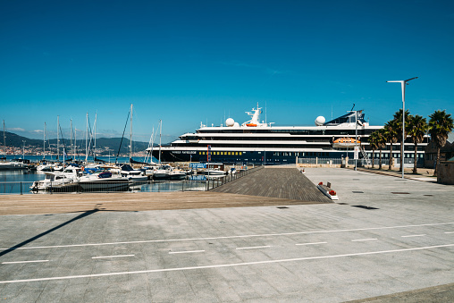 Vigo, Spain - September 23, 2022: Boats moored in the port of Vigo, Galicia, Spain. Cruise ship World Navigator in the background