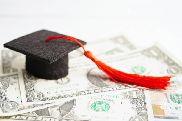 istock Graduation gap hat on US dollar banknotes money, Education study fee learning teach concept. 1426861427