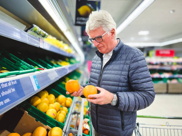 istock Senior man looking at citrus fruit in supermarket 1426862038