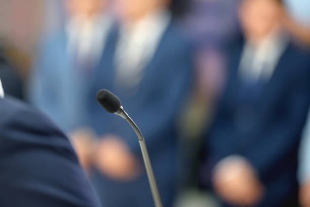 Close up of a microphone at a business conference, people in background