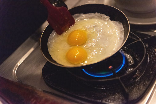 Preparing a sunny side up eggs for breakfast, using gas stove