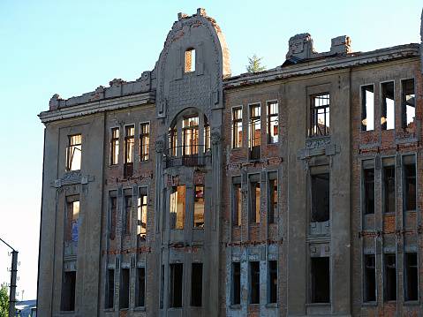 Facade of an old abandoned destroyed multi-storey building. Kharkiv city, Ukraine