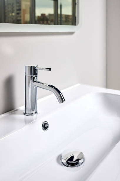 istock Bathroom interior modern design sink under mirror with window reflection. Interior of bathroom with washbasin and faucet elongated rectangular shape bowl. 1426874783