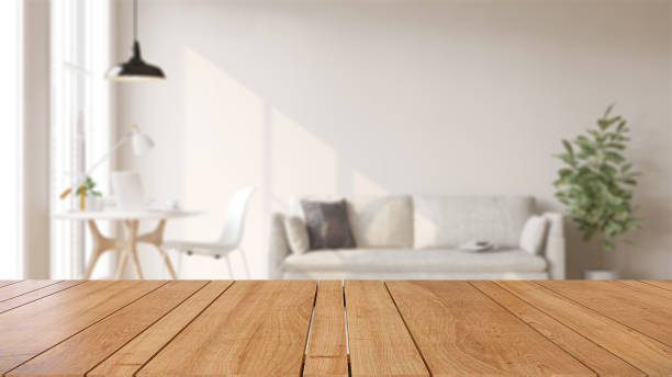 tavolo in legno o piano di lavoro in soggiorno bianco moderno e di lusso con parete bianca, scrivania, divano e pianta d'appartamento con luce solare a casa - wood product foto e immagini stock