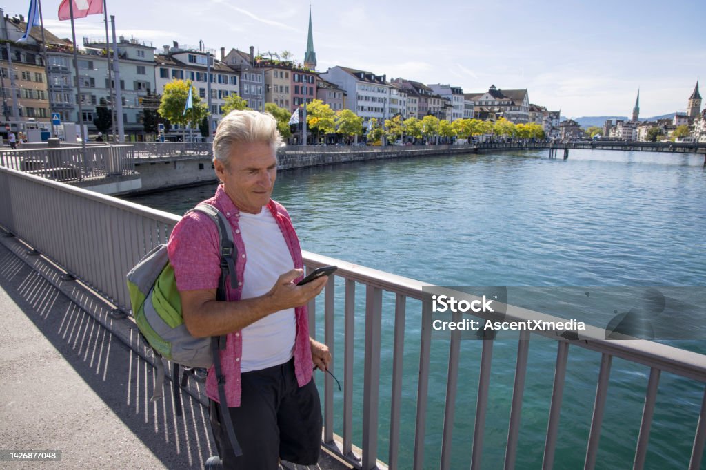 Man walks along streets of old town, uses smart phone Zurich old town, Zurich,  Zurich Canton Zurich Stock Photo