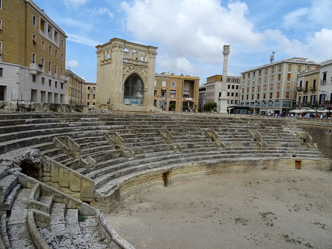 Lecce, Salento, Apulia region, Italy - 25 August 2022: The Roman Amphitheater, the Seat (or Palazzo del Seggio) and the Column of Sant'Oronzo in piazza Sant'Oronzo