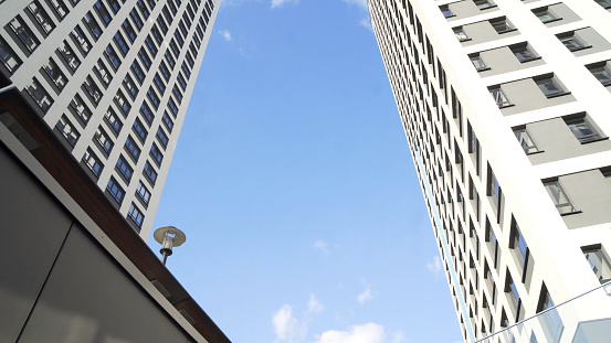 Skyscrapers in the business district of New York city on a bright blue sky background. Modern buildings in a big city center, consepts of economics, business.