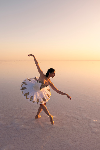 Ballerina dancing in Tuz lake at sunset and her reflection in the water -Salt Lake- Turkey
