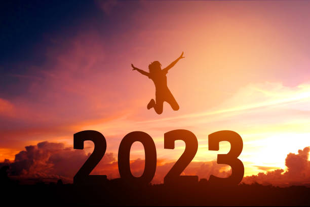 2023 Newyear Silhouette young woman jumping to Happy new year concept. stock photo