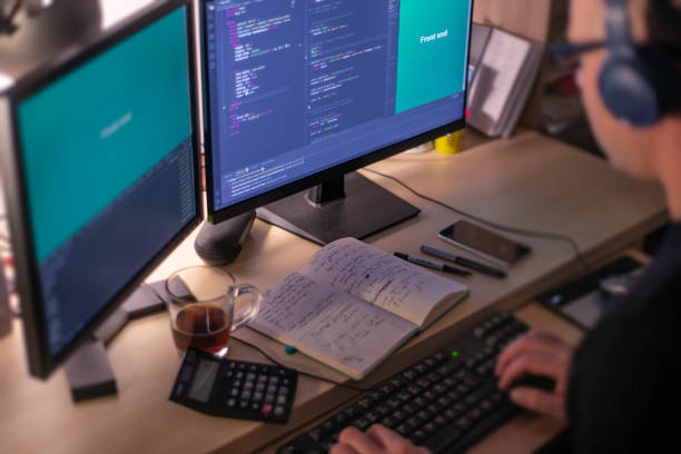 istock A male programmer coding in the night time while listening music with stereo headphones. Front end development concept. 1426897595
