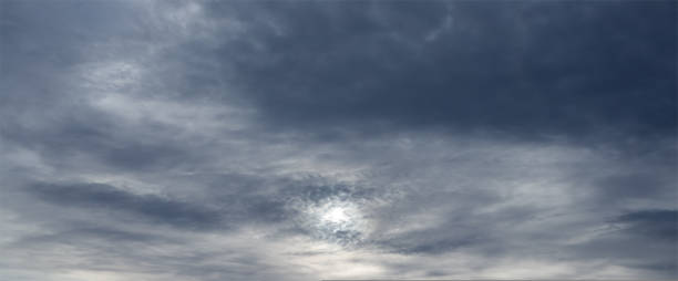 istock Panorama of sky with sun through stormy clouds 1426899876