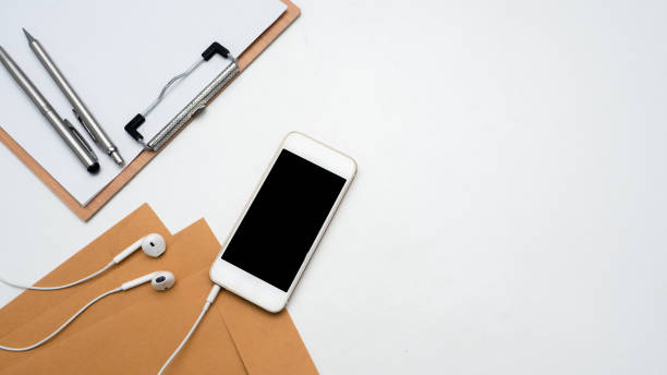 istock Close up mobile phone with ear phone,wood board document and envelope top view copy space 1426904351